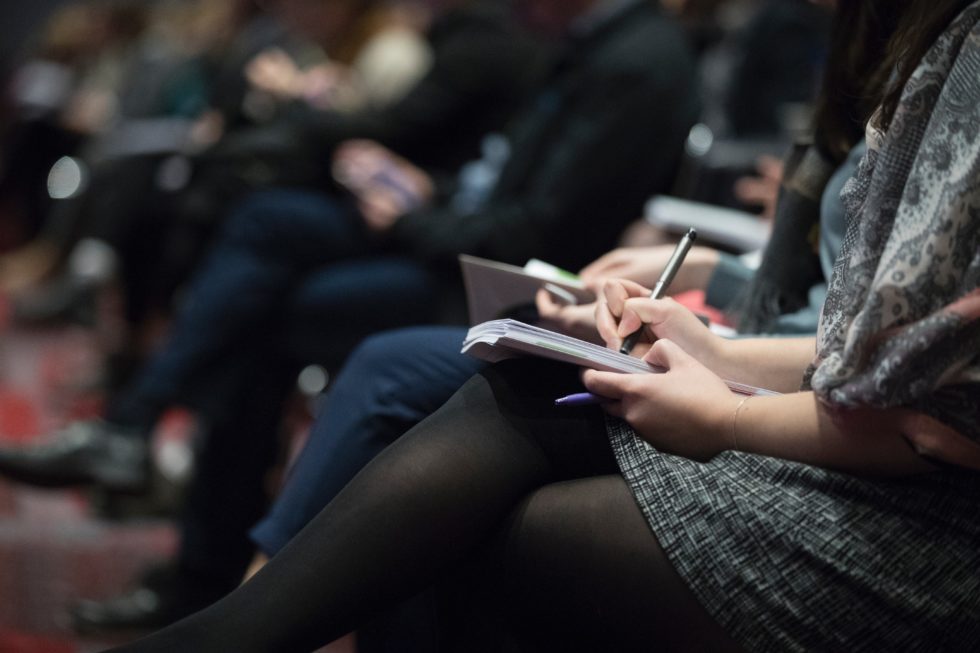 a group of people seated at the P2P forum conference.