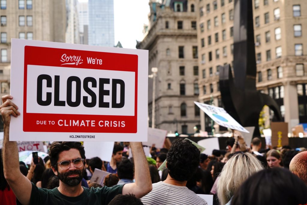 a man holding a sign at a protest (grassroots fundraising)
