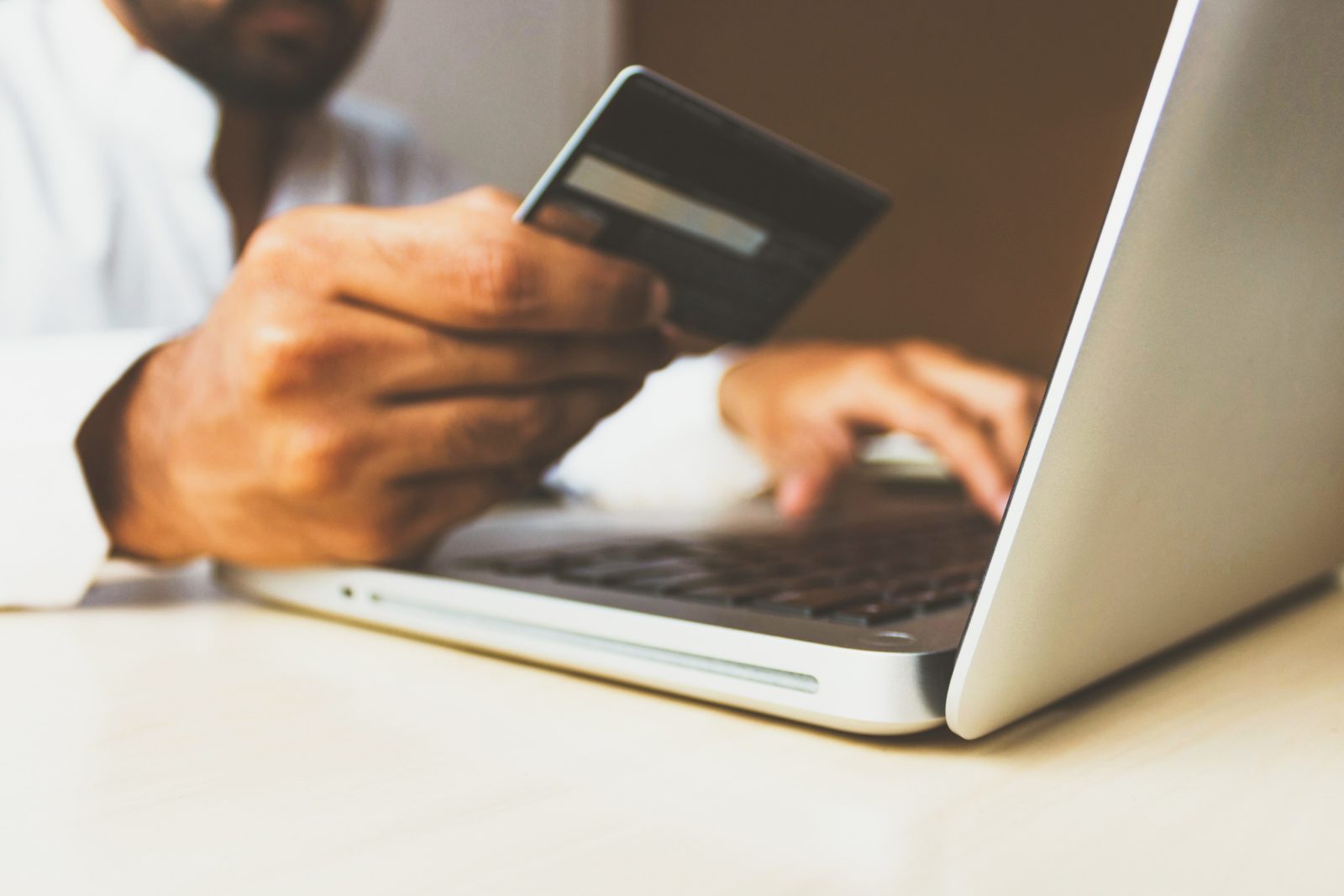 Man entering credit card information on a laptop