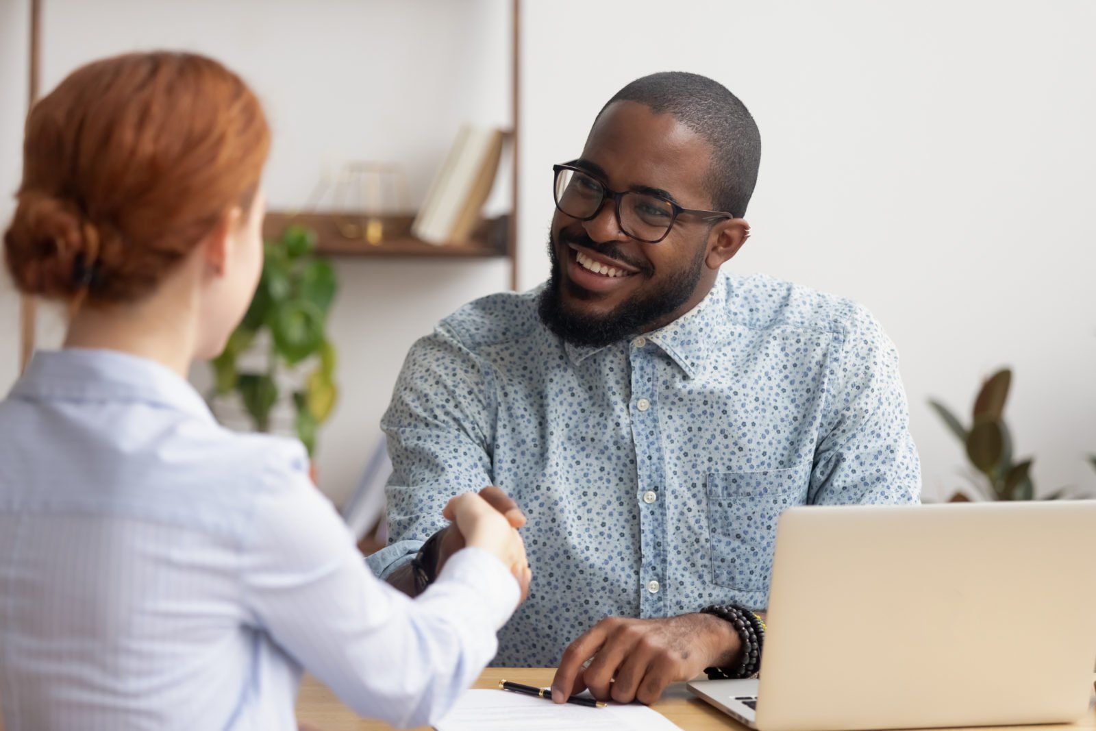 donor acquisition: Smiling African American hr manager shaking hand of candidate at job interview, hiring, greeting, good first impression concept, successful negotiation, friendly businessman handshaking with client