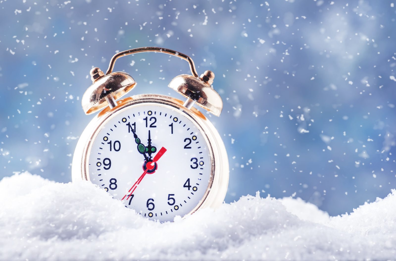Corporate matching gift appeals are important year round, but especially in Q4. In this image, a gold metal alarm clock rests in a bank of snow against a blue snowy background.
