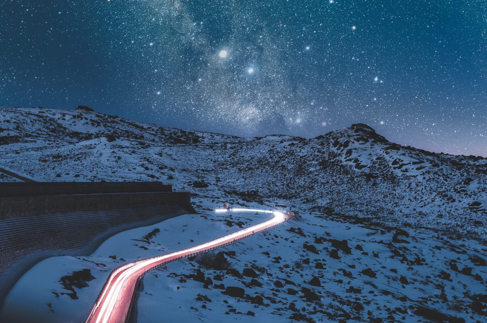 A lighted road in a snow covered desert landscape