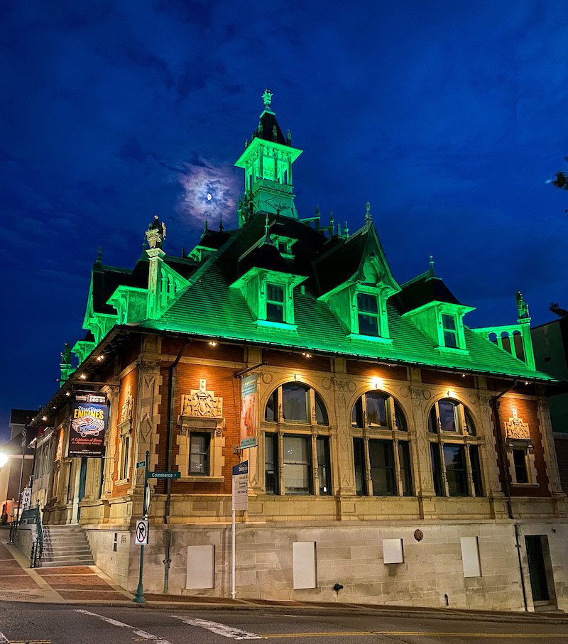 Historic building lit at night so roof looks green.