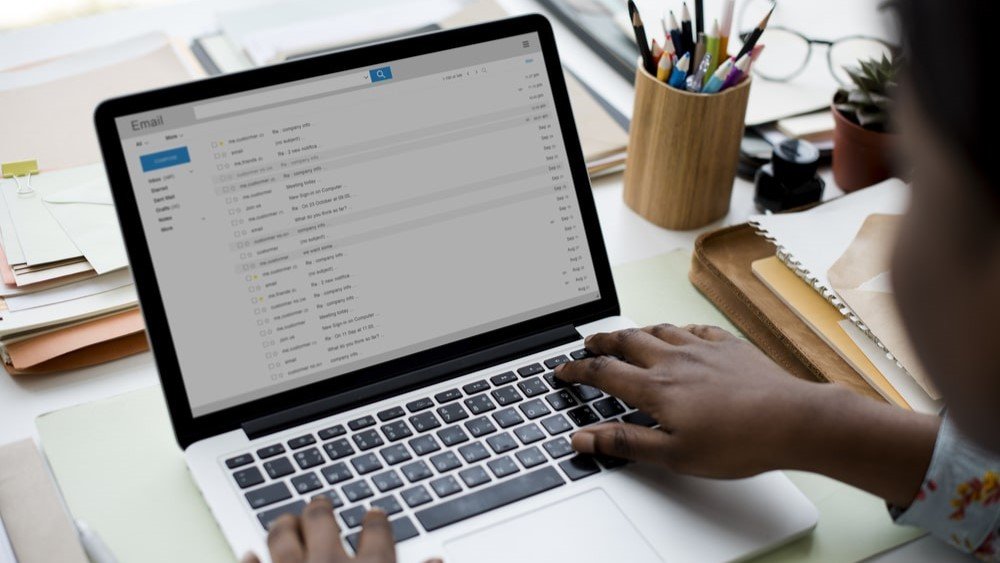 Email fundraising best practices centered around personalization can help you grab your donors attention when your message reaches their inbox. In this image, a woman sits in front of an open laptop, reviewing her email inbox.