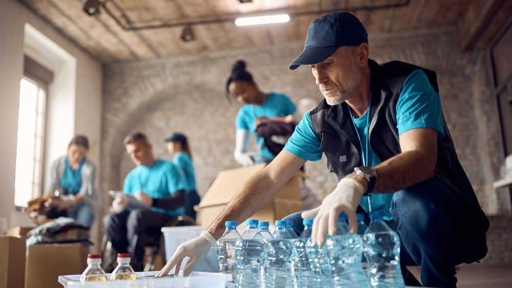 GivingTuesday is a collaborative day of global giving, with many nonprofits holding fundraising events, food drives, and more. In the above image, a volunteer sorts bottles at a donation site.