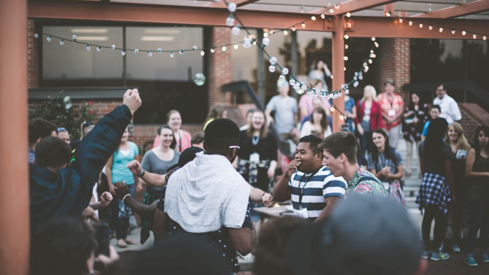 Enjoy this list of proven nonprofit event ideas. In this image, a group of adults are having a great time in an outdoor restaurant setting.