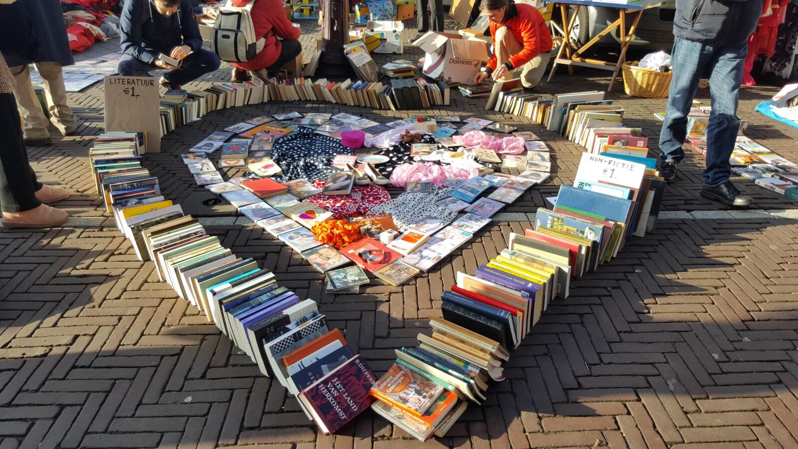 donated books have been arranged on the ground in the shape of heart as a part of an easy nonprofit fundraiser.
