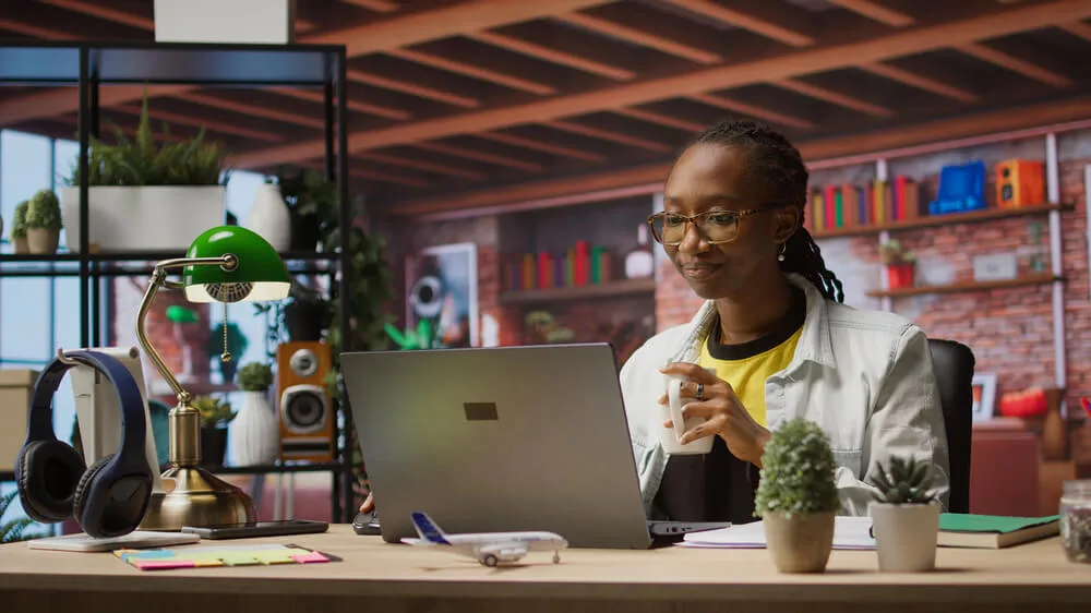 A woman sitting at her laptop at the office of her nonprofit writing a fundraising email that is going to convert.